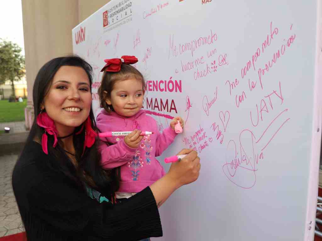 Madre e hija firmando en un muro de la campaña