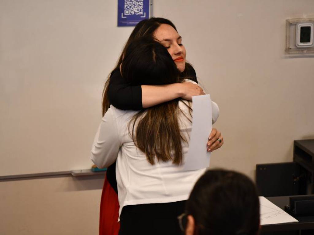 La Dra. Montserrat Montecino abrazando a una de las estudiantes certificadas